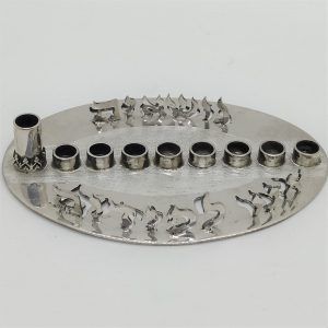 Original miniature handmade Hanukah Menorah silver oval miniature  cut out with the words saying in Hebrew " We are carrying the torch".