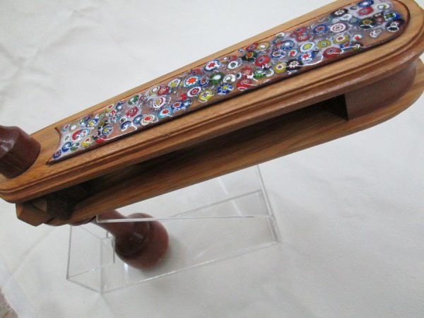 Purim Grogger wood & enameled natural Wood & a bar of enamel hand painted flower field. Dimension 5.5 cm X 25 cm X4.7 cm approximately.