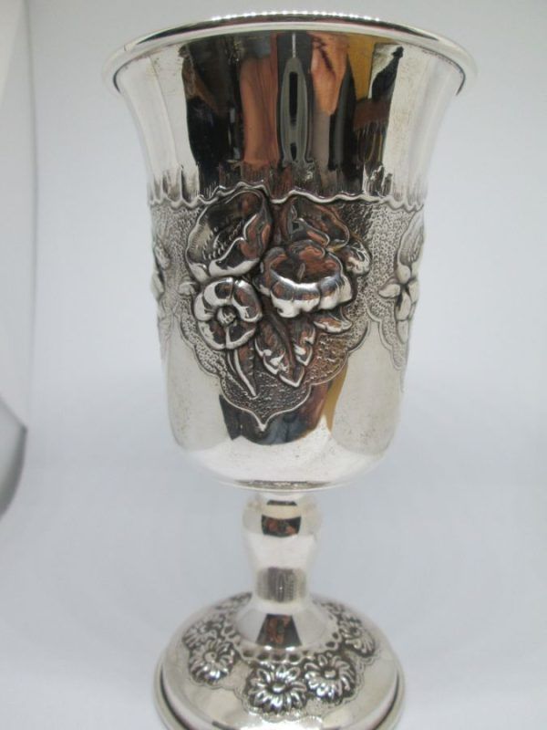 Sterling Silver Lilly flowers Kiddush cup with Lilly flowers designs around & sun flowers around base. Dimension diameter 7.3 cm X 13.5 cm approximately. 