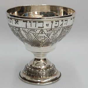 Silver Kiddush Cup MagenDavid star and menorah designs on. On top there is too the complete wine blessing " ברוך אתה.... בורא פרי הגפן".