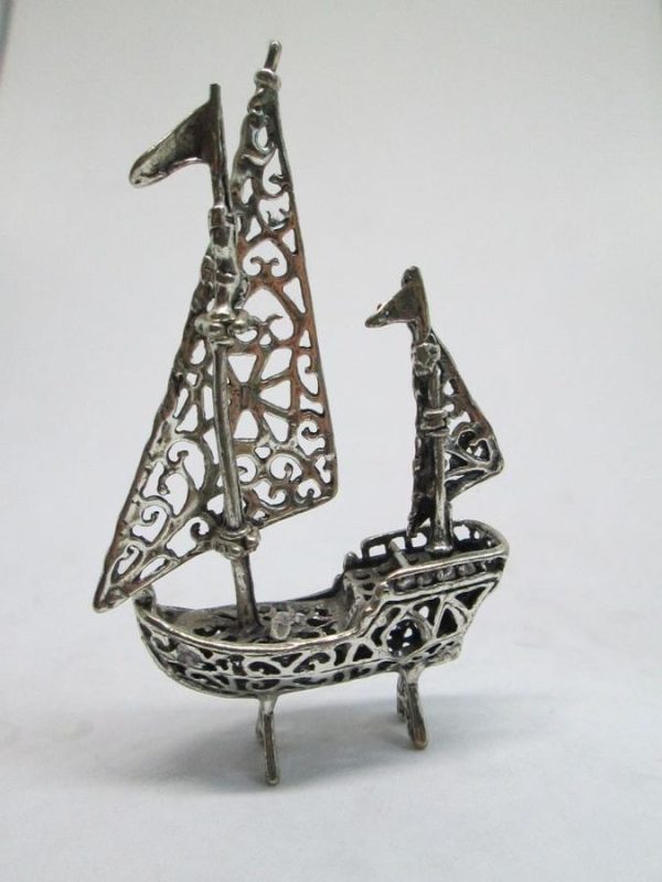 A handmade sterling silver miniature Cutout sailing boat Sculpture with two sailing poles. Dimension 4.4 cm X 1.5 cm X 7.5 cm approximately.
