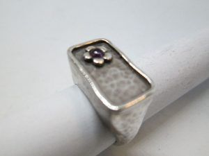 Handmade sterling silver contemporary style Amethyst flower silver ring set with Amethyst stone in center of flower.