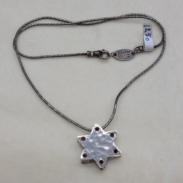 Handmade contemporary sterling silver and 14 carat gold MagenDavid Star Hammered Gold hammered set with Garnets on one side of star.