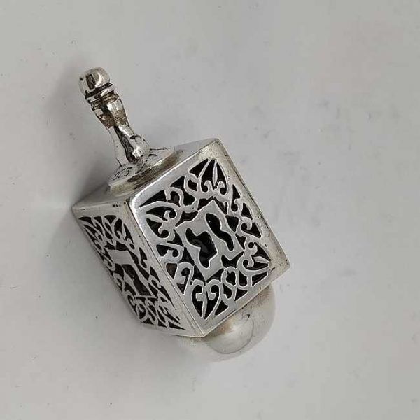 Chanuka Dreidel Silver Cutout designs handmade sterling silver. It has the letters a miracle happened here. Size 1.7 cm X 1.7 cm X 4.4 cm.