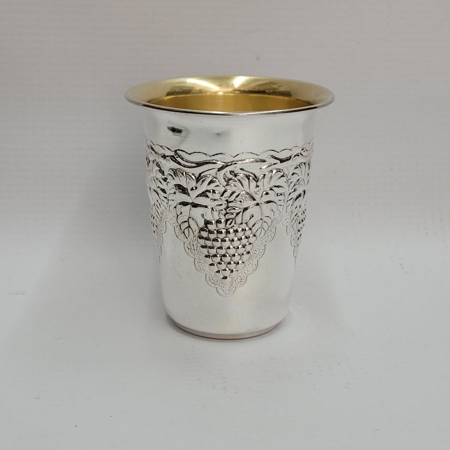 Handmade sterling silver Schnapps cup grapes leaf around designs embossed all around cup. It is hand embossed with vine grapes designs around top of cup.