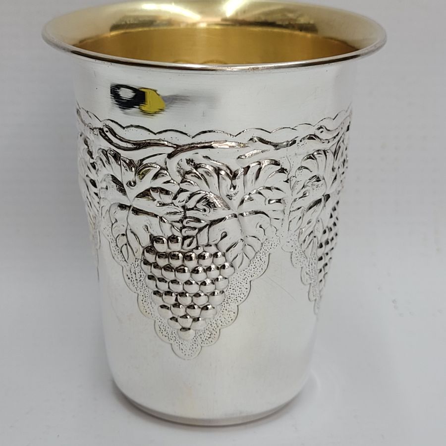 Handmade sterling silver Schnapps cup grapes leaf around designs embossed all around cup. It is hand embossed with vine grapes designs around top of cup.