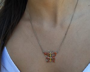 A handmade original design Silver Necklace Mazal Tov made out of the Hebrew words Mazal Tov Good luck enameled with orange colors.