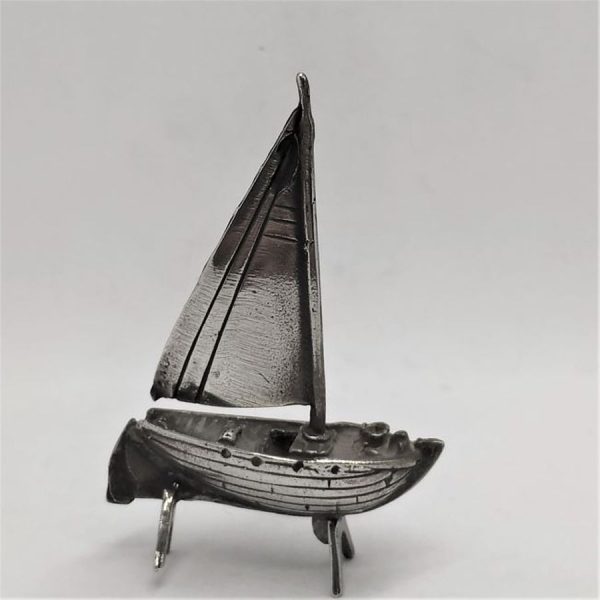 A handmade sterling silver miniature One sail boat statue with one sailing pole .Dimension 4  cm X 1.2  cm X 5.6 cm approximately.