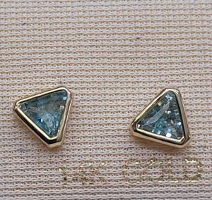 Handmade 14 carat gold blue Topaz stud earrings set with two triangle faceted blue Topaz stones stones handmade.   Dimension 0.7 cm X 0.6 cm approximately.