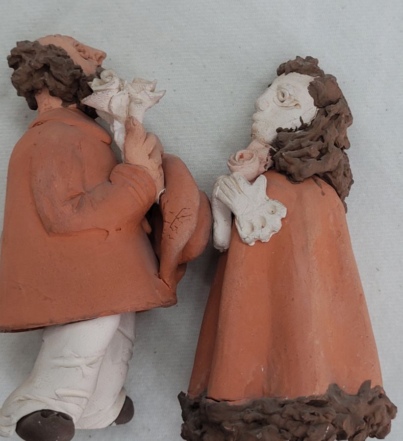 Handmade couple pottery wedding proposal statues where the man gives his future wife a flower bouquet made by Nefissa 4.8 cm X 10 cm X 5 cm approximately.